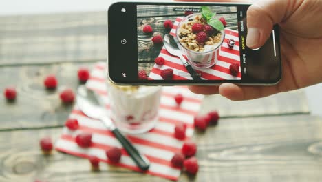 crop hand making picture of dessert