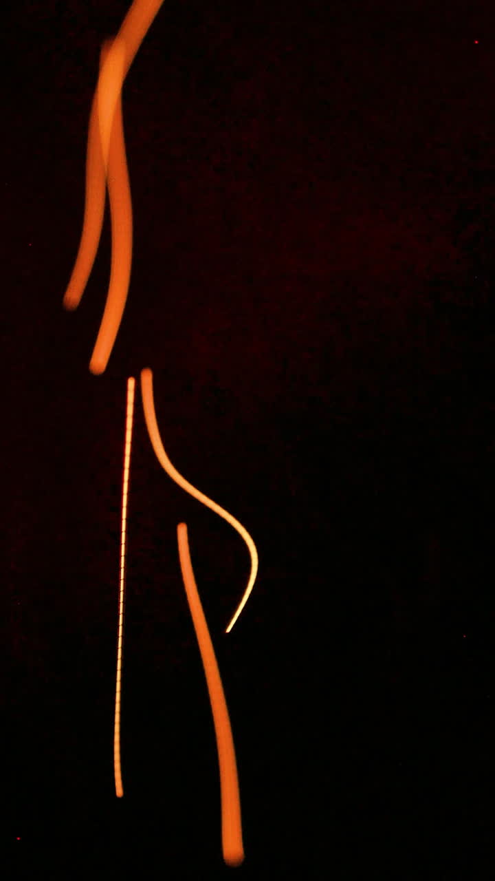 Ethereal Orange and Yellow Light Trails on Dark Background