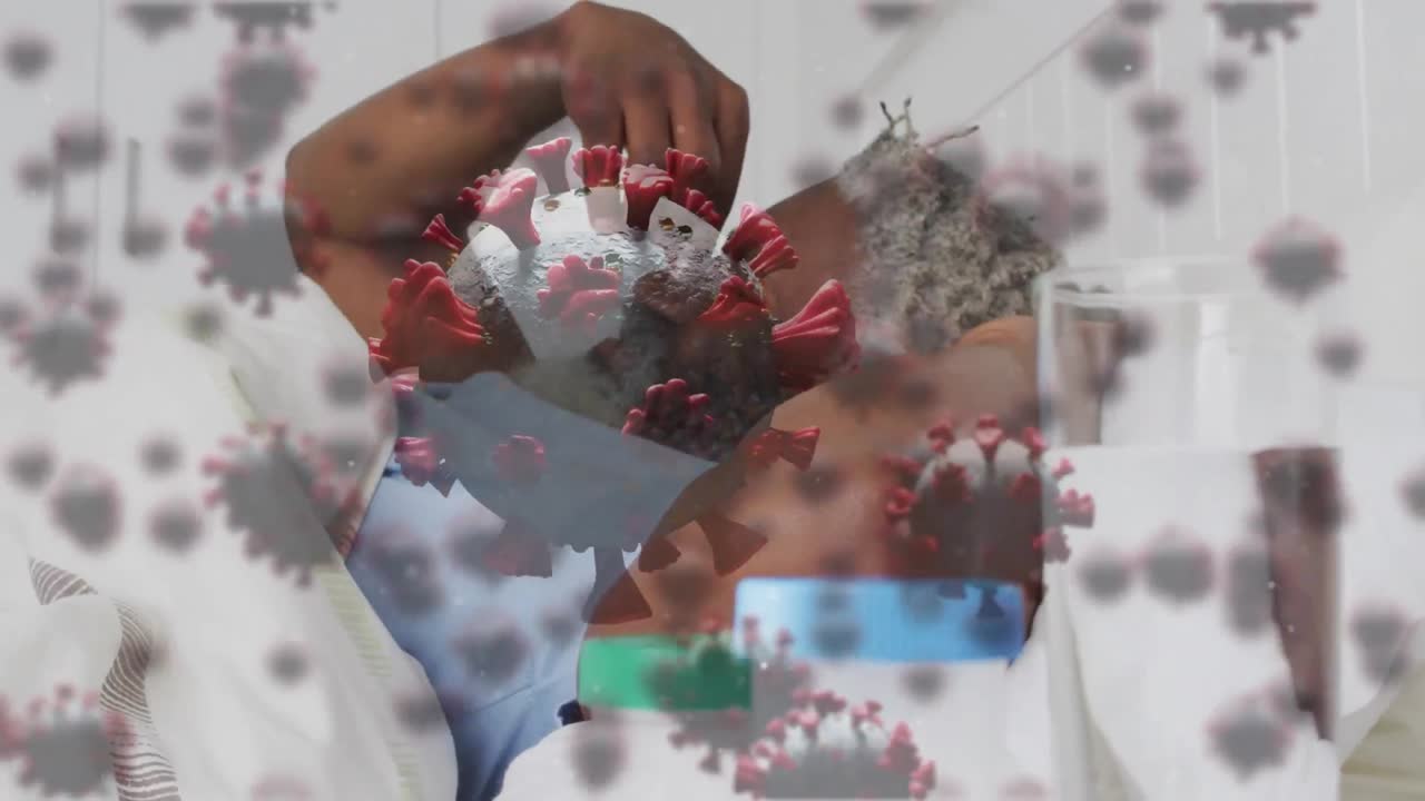 múltiples células de covid-19 flotando sobre un hombre mayor afroamericano en una cama de hospital