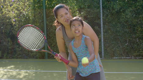 playing tennis, mother and daughter enjoying outdoor activity on sunny day