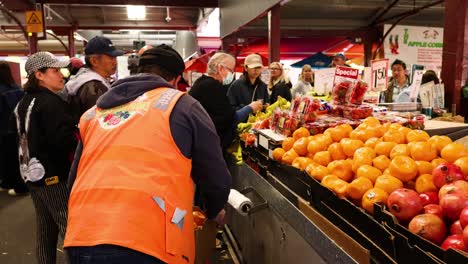 vendor arranging fruits at a busy market