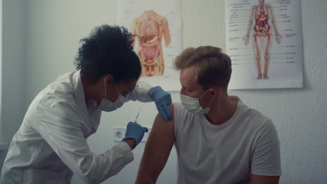 physician making vaccine injection in man shoulder. doctor vaccinating patient.