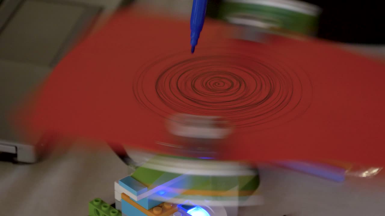 robot girando papel con alguien dibujando con un lápiz de filtro azul, arte tecnológico