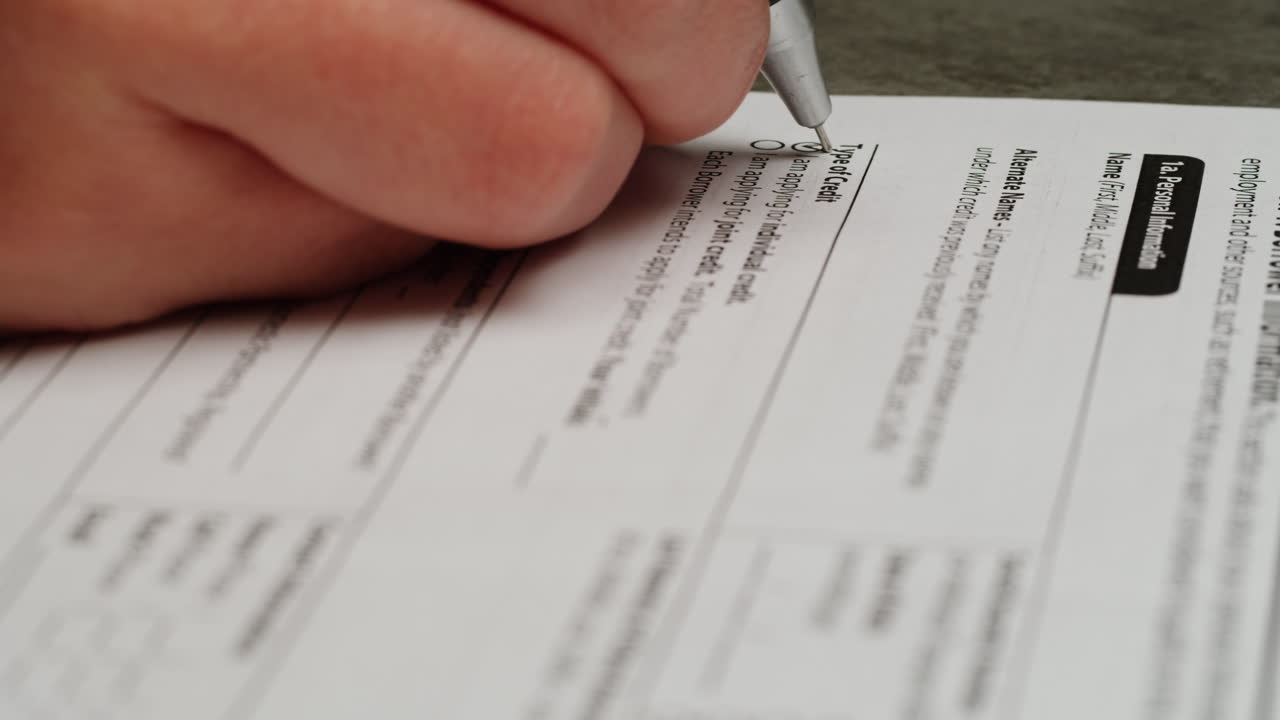Close-up of Hand Filling Out a Financial Credit Application Form