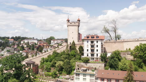 Flying-up-to-castle-tower-and-revealing-downtown-Luzern,-Switzerland