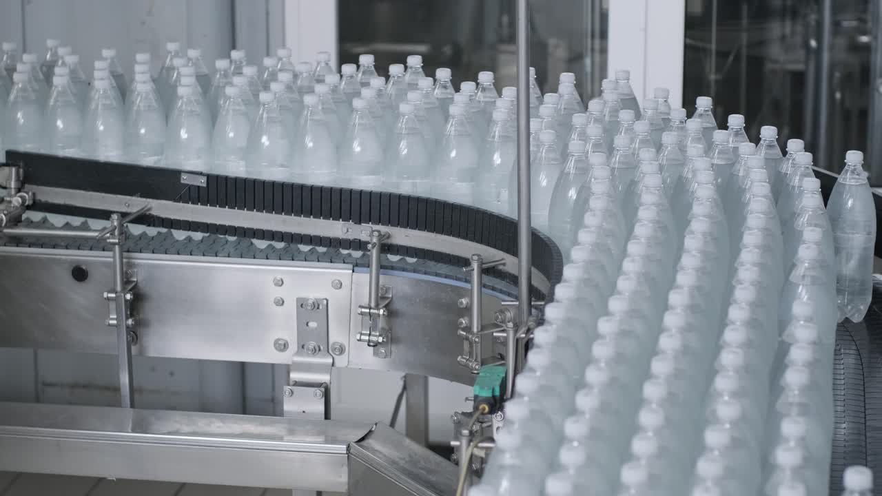 cinta transportadora con botellas de agua potable en una planta de bebidas moderna