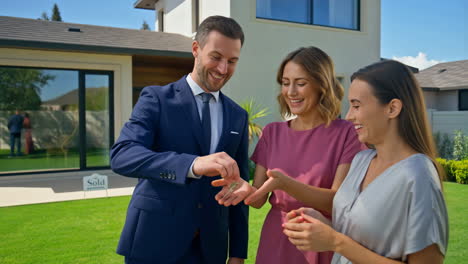 real estate agent hands over keys to happy new homeowners
