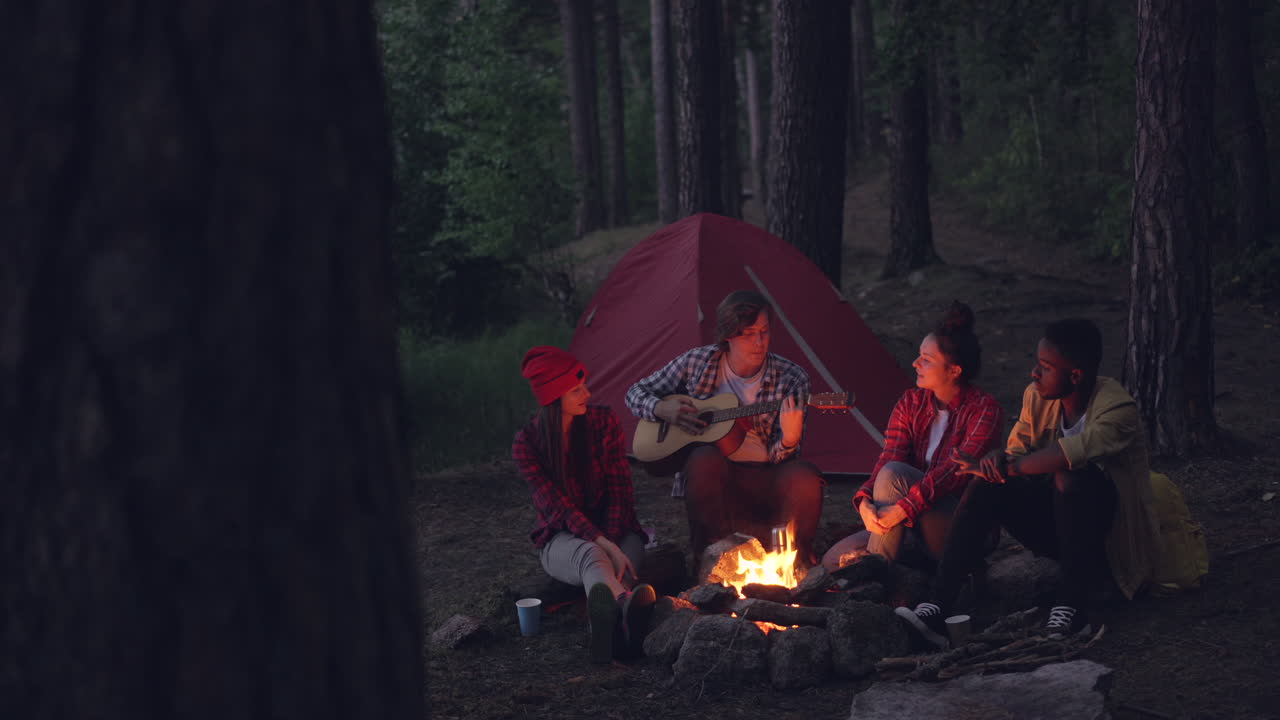 Friends Enjoying a Campfire in the Forest at Night