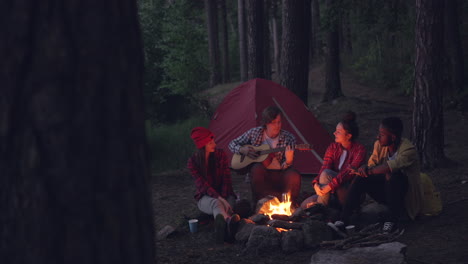 friends enjoying a campfire in the forest at night