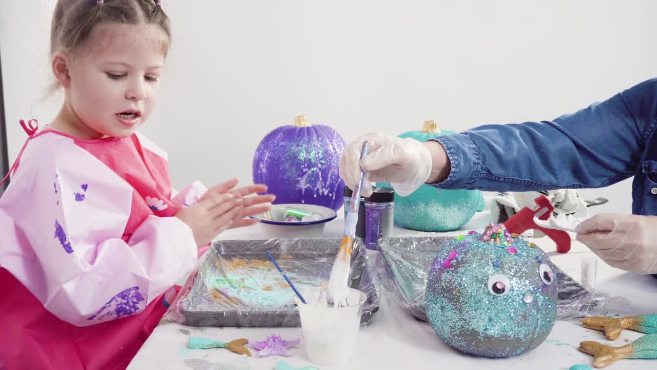madre e hija decorando calabazas de arte