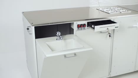 commercial kitchen water station with sink and cash drawer