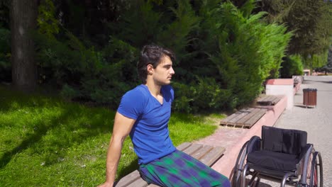 un joven discapacitado está sentado en un banco.