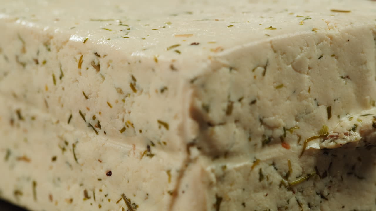 Fried tofu with sesame seeds and spices on cast iron pan, cooking japanese salad. Healthy ingredient for cooking vegan vegetarian diet food. Roasted tofu over black background.
