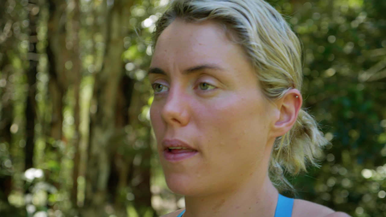 primer plano de la atleta rubia respirando mientras se estira y hace ejercicios antes de la carrera, cámara lenta de 4k