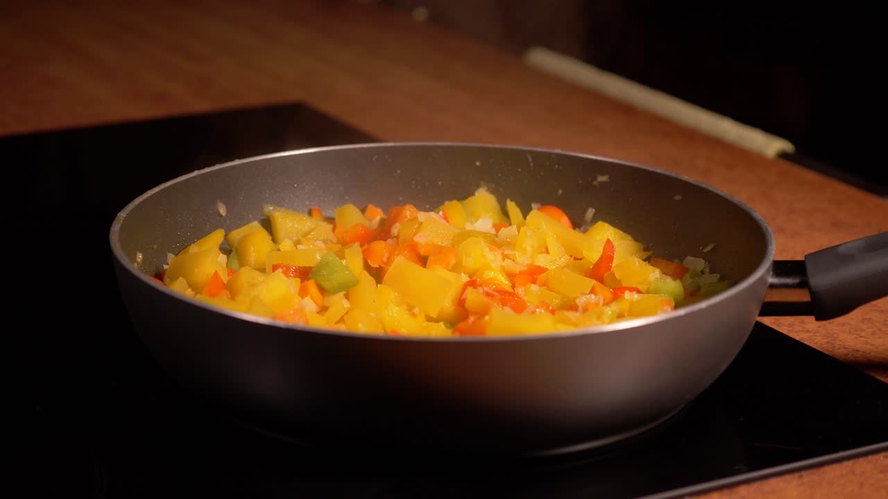 Opening lid of a frying pan full of boiling vegetables in home kitchen