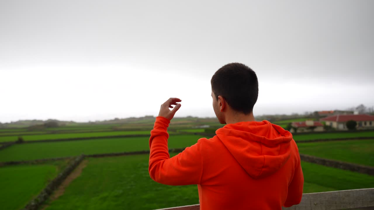 Tourist enjoys Atlantic view at Terceira's farm fields viewpoint