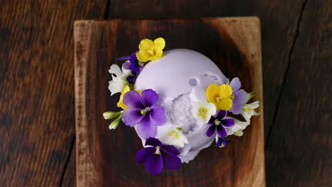 skull-shaped dessert adorned with colorful edible flowers on wood