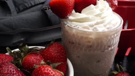 pink cocktail drink with strawberry liqueur, vanilla vodka and cream. party drink with strawberries. fruit cocktail with fresh strawberries as a garnish. cold and refreshing