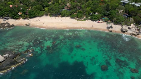 Cinematic-drone-tilt-up-reveal-over-beautiful-ocean-with-turquoise-waters