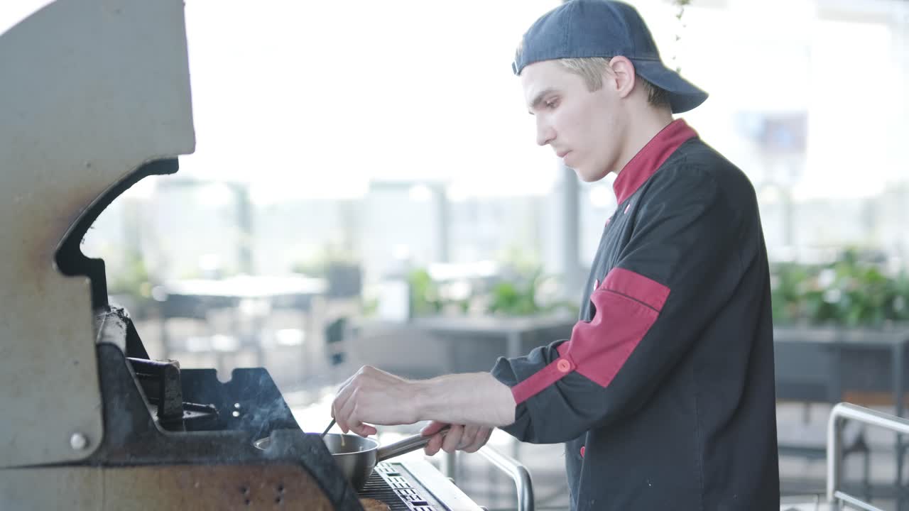 шеф-повар готовит макароны на открытой станции гриля