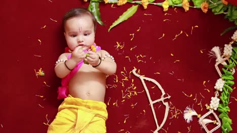 cute indian boy dresses as lord rama with bow and flowers from top angle