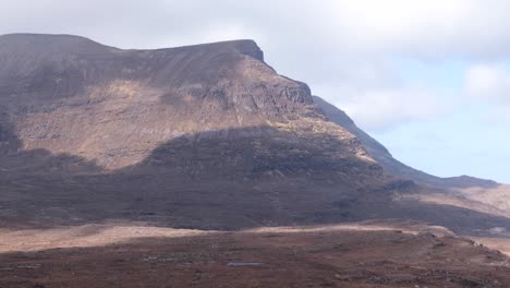 Dramatic-cloud-shadows-rolling-over-the-wild,-rugged-and-remote-mountainous-landscape-of-Quinag-Sail-Gharbh-in-Assynt-district,-highlands-of-Scotland-UK