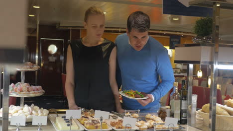 Man-and-woman-looking-at-desserts-in-cafe