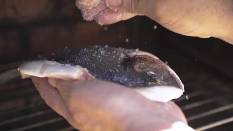 putting salt on the inside of a fish in slow motion