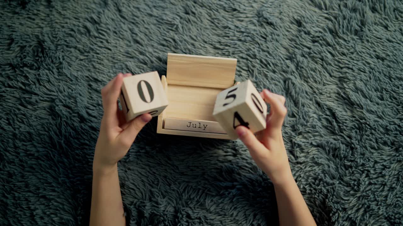 American Independence Day calendar blocks. Boy play with wooden block calendar.
