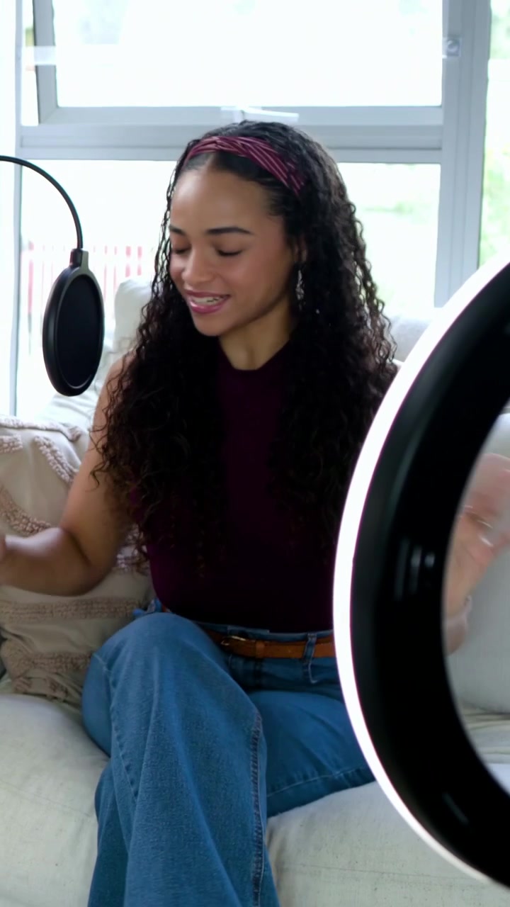 Vertical video: Checking frame host adjusting phone in ring light at home aligning mic to record