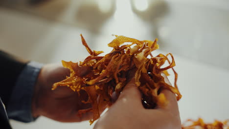 close up shot of a man's hands holding yellow aromatic dried spice herbs while checking it