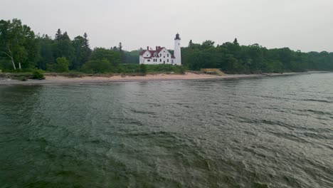 Aerial-flyto-Point-Iriquois-Lighthouse-from-over-water,-Lake-Superior,-Michigan