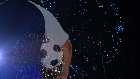 animation of caucasian male soccer player with football over fireworks