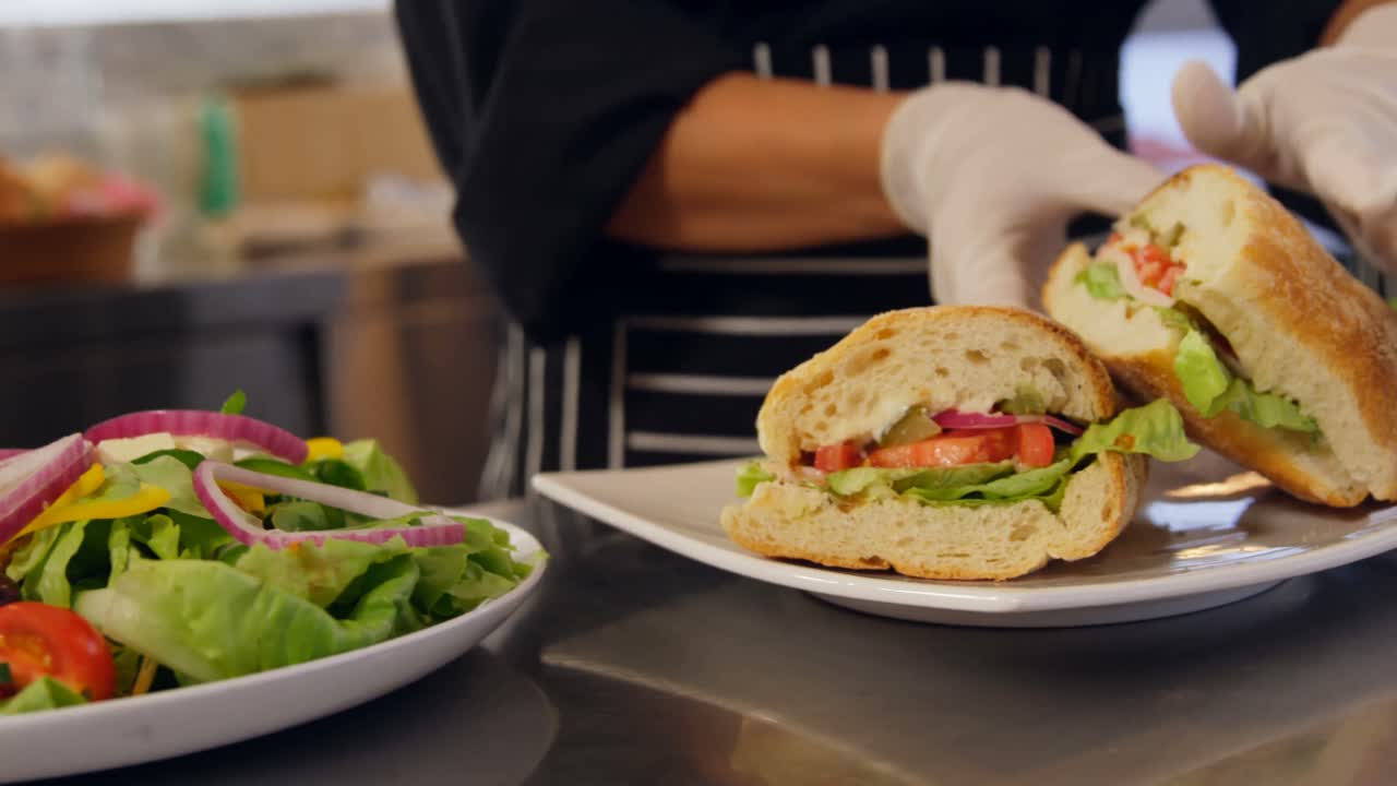 chef preparando un sándwich en una cocina comercial 4k