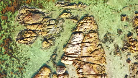 Azure-crystal-clear-sea-with-seaweed-and-rock-in-the-water