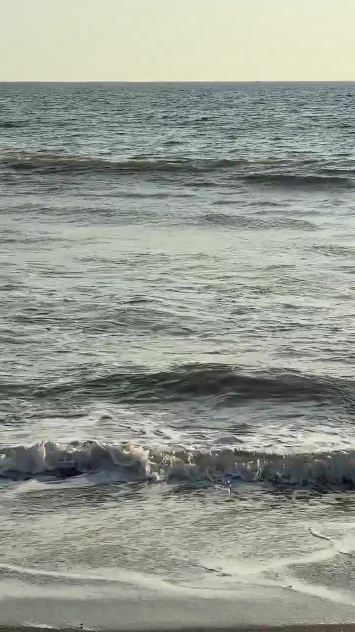 Onde marine che si infrangono dolcemente su una spiaggia sabbiosa