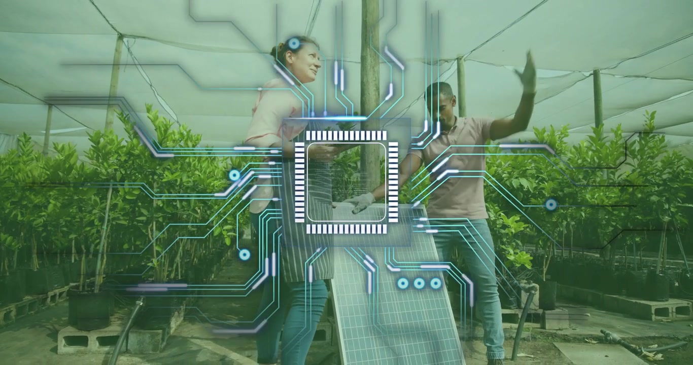 Worker mounting solar panel while specialist tapping tablet in greenhouse showing tech connectivity