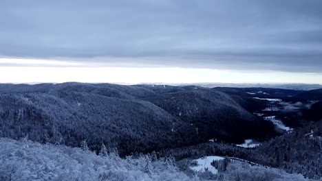 Aerial-winter-landscape-reveal-of-valley-of-the-lakes-in-Hautes-Vosges-with-snow-capped-forests