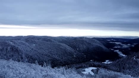 aerial winter landscape reveal of valley of the lakes in hautes-vosges with snow-capped forests