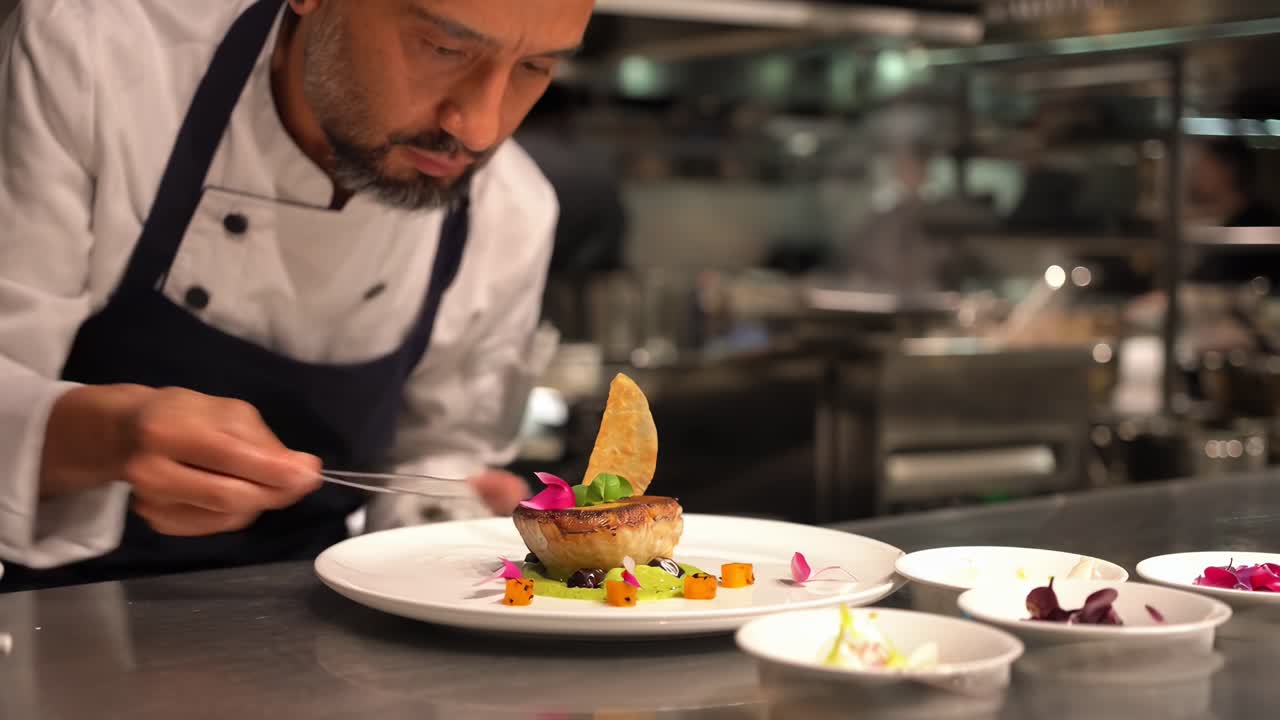 Video ravvicinato di uno chef che impiattata cibo gourmet in una cucina, che mette in mostra l'arte culinaria