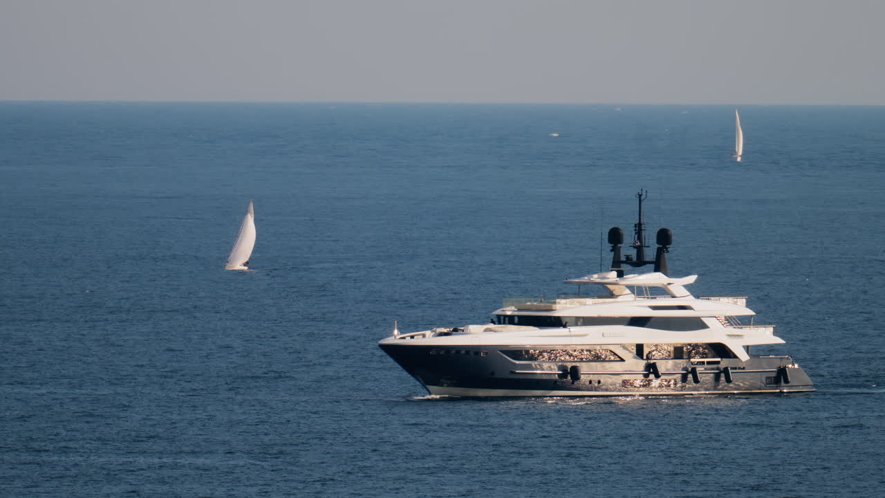 A white boat moving on the sea with other small boats on the background in the French Riviera