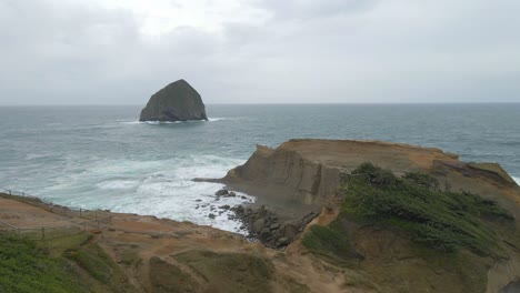 Aufschlussreiche-Szene-Eines-Meeresstapels-An-Einem-Wunderschönen-Sandstrand-In-Oregon-An-Einem-Bewölkten-Tag