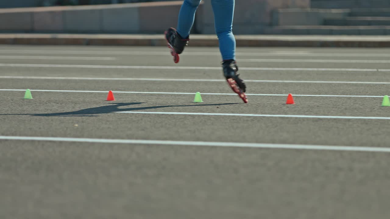 Spinning around on roller skates, the roller goes around the cones and turns around itself. Professional elements in roller sports, training. 4k, 10bit, ProRes