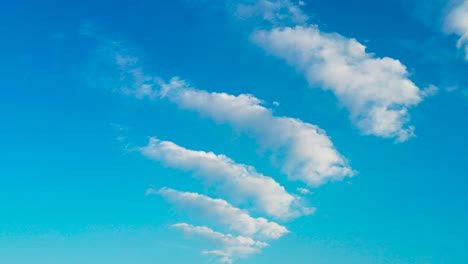 vibrant blue sky with unusual white cloud pattern from small to big shape