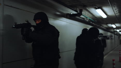 SWAT-team-walking-in-dark-corridor.-Special-forces-group-pointing-weapons