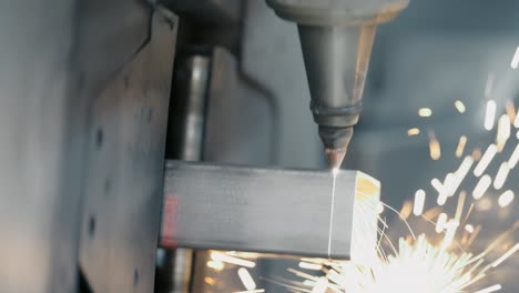 tube laser cutter is cutting through a stainless steel tube