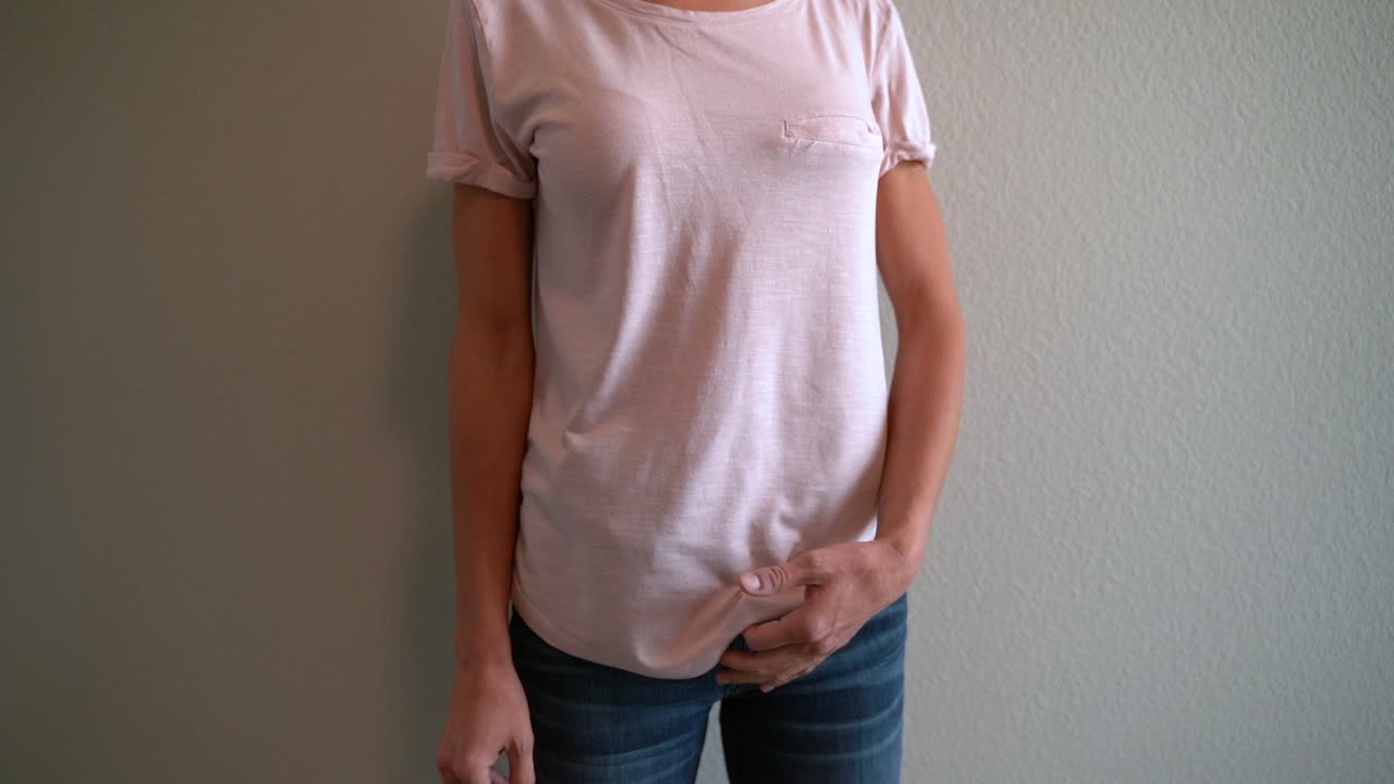 cámara lenta de la mujer tirando de su camisa y agarrando una pistola de mano oculta para protección