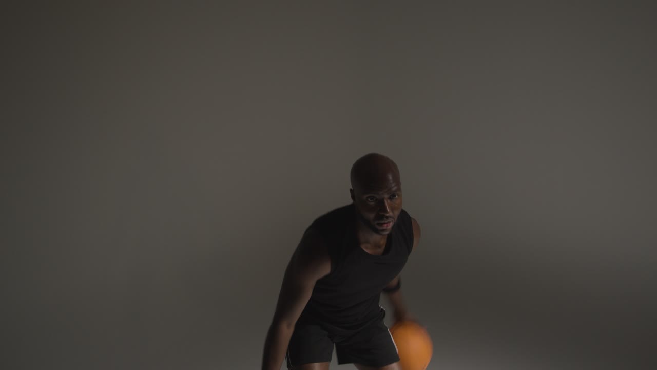 prise de vue d'action en studio d'un joueur de basket-ball dribblant la balle et tirant en temps réel
