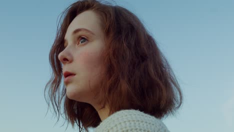 profile of a young woman looking up at the sky