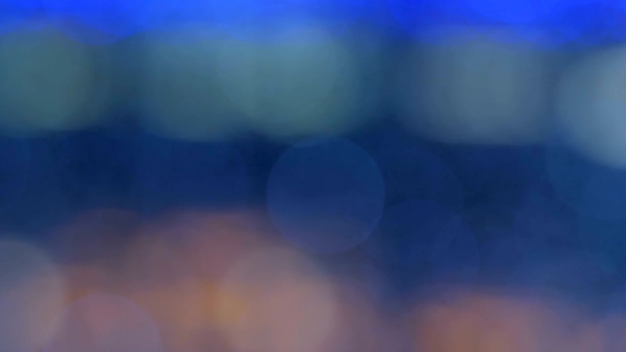 Night abstract background is defocused with nice bokeh. Blurred Christmas Lights Bokeh. Pan across blur .